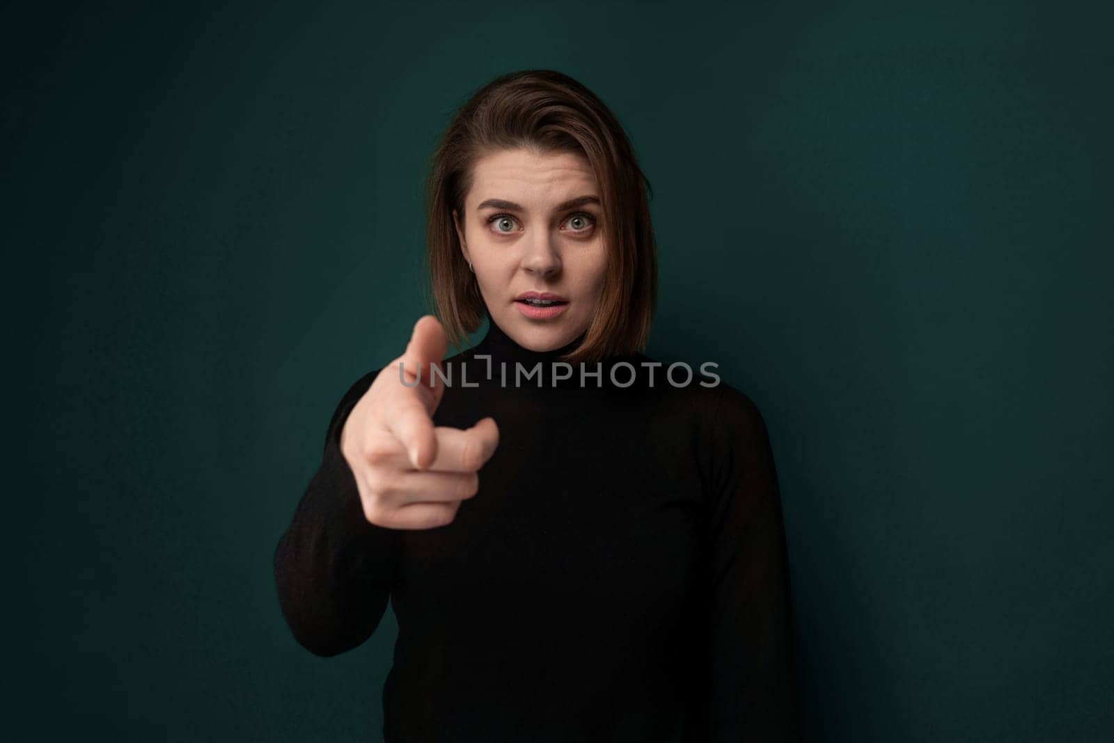 Woman Pointing at Camera on Green Background by TRMK