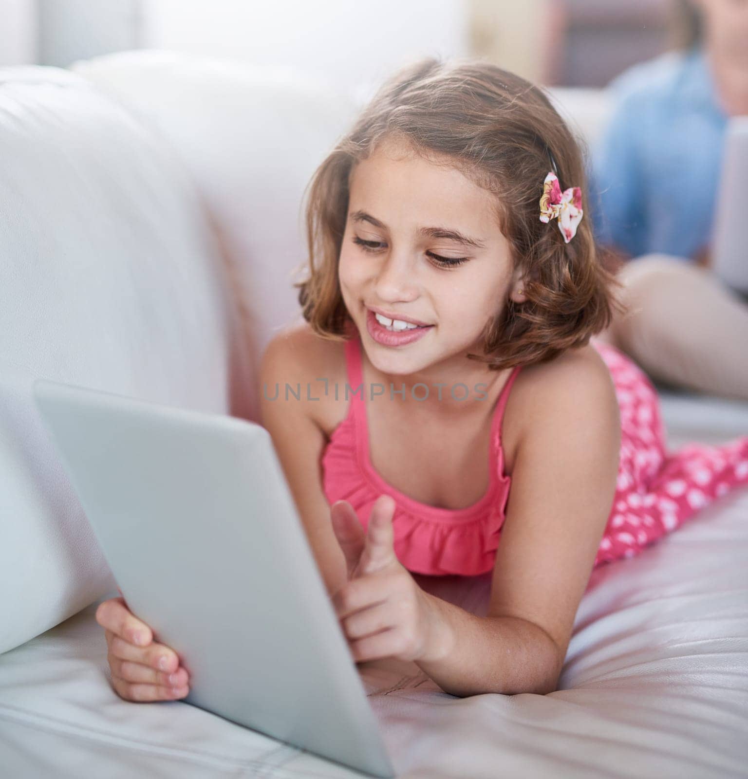 Girl, child and relax on sofa with tablet for games, movies or elearning platform with happiness and development. Internet, streaming and subscription with ebook on online education website at home by YuriArcurs