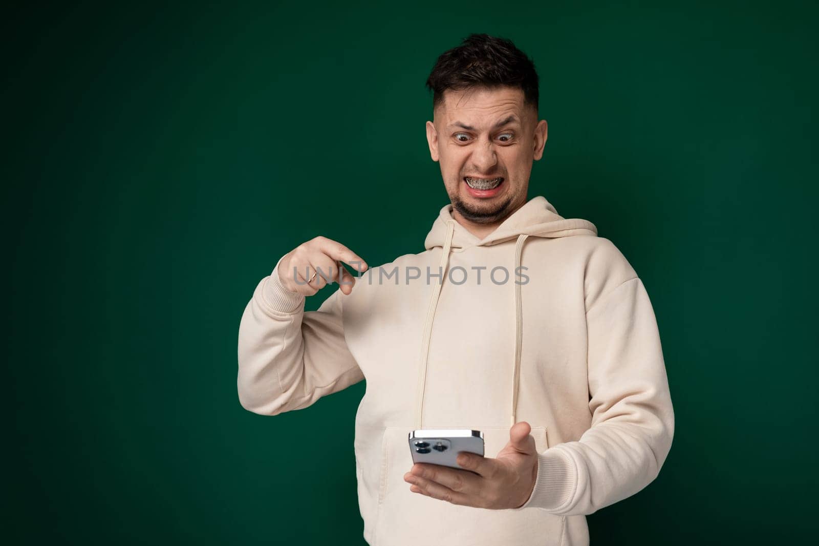 Man in Hoodie Holding Cell Phone by TRMK