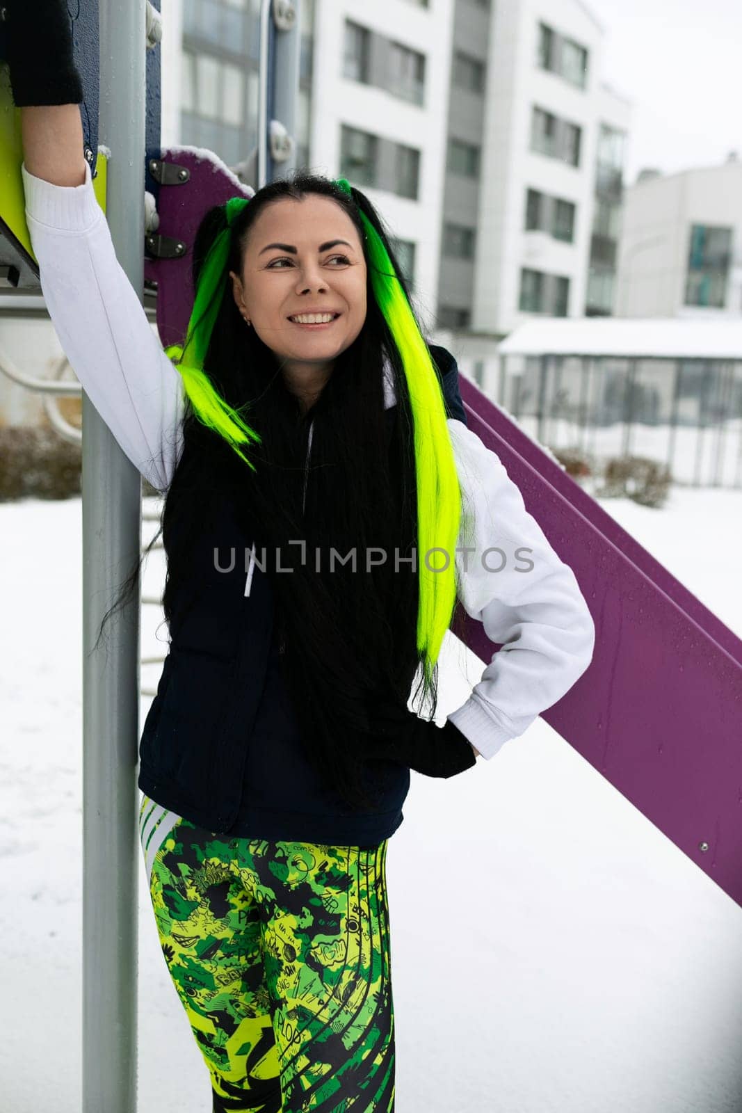 Woman With Green Hair Standing Next to Purple and Pink Slide by TRMK