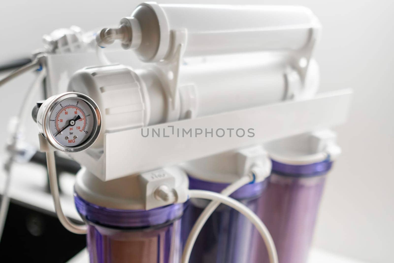 Pressure gauge and mineralizer in a reverse osmosis system for water purification at home.