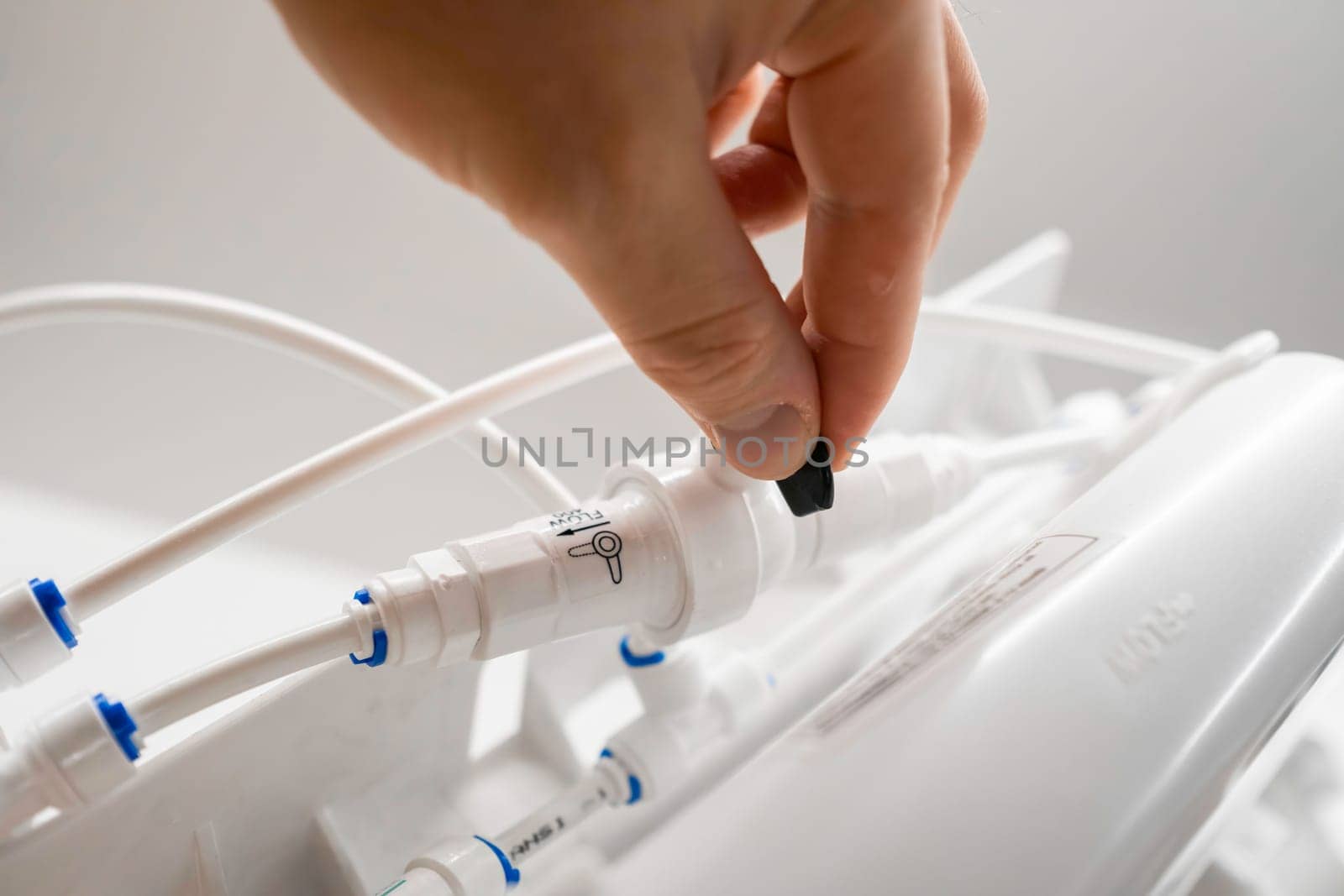 Man hand connect tubes in osmosis water purification filter for home use by vladimka