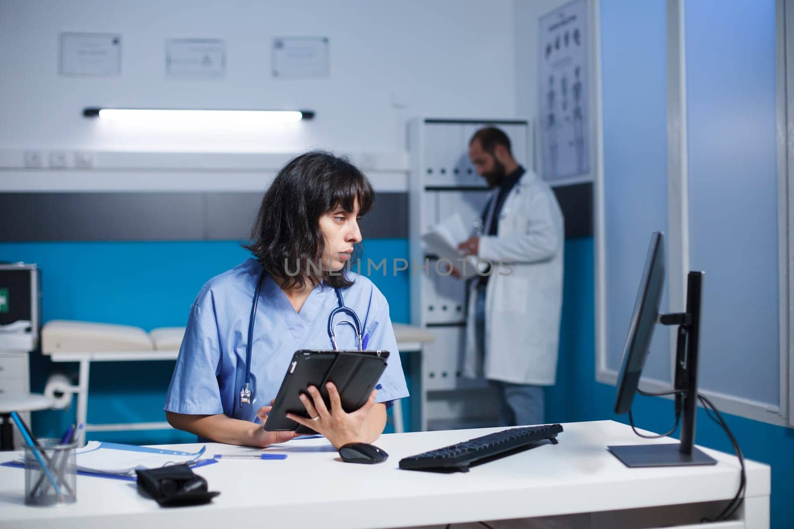 Nurse using smart tablet for checkups by DCStudio