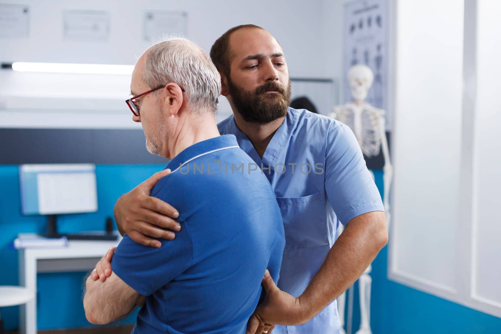 Nurse helps man with chiropractic care by DCStudio