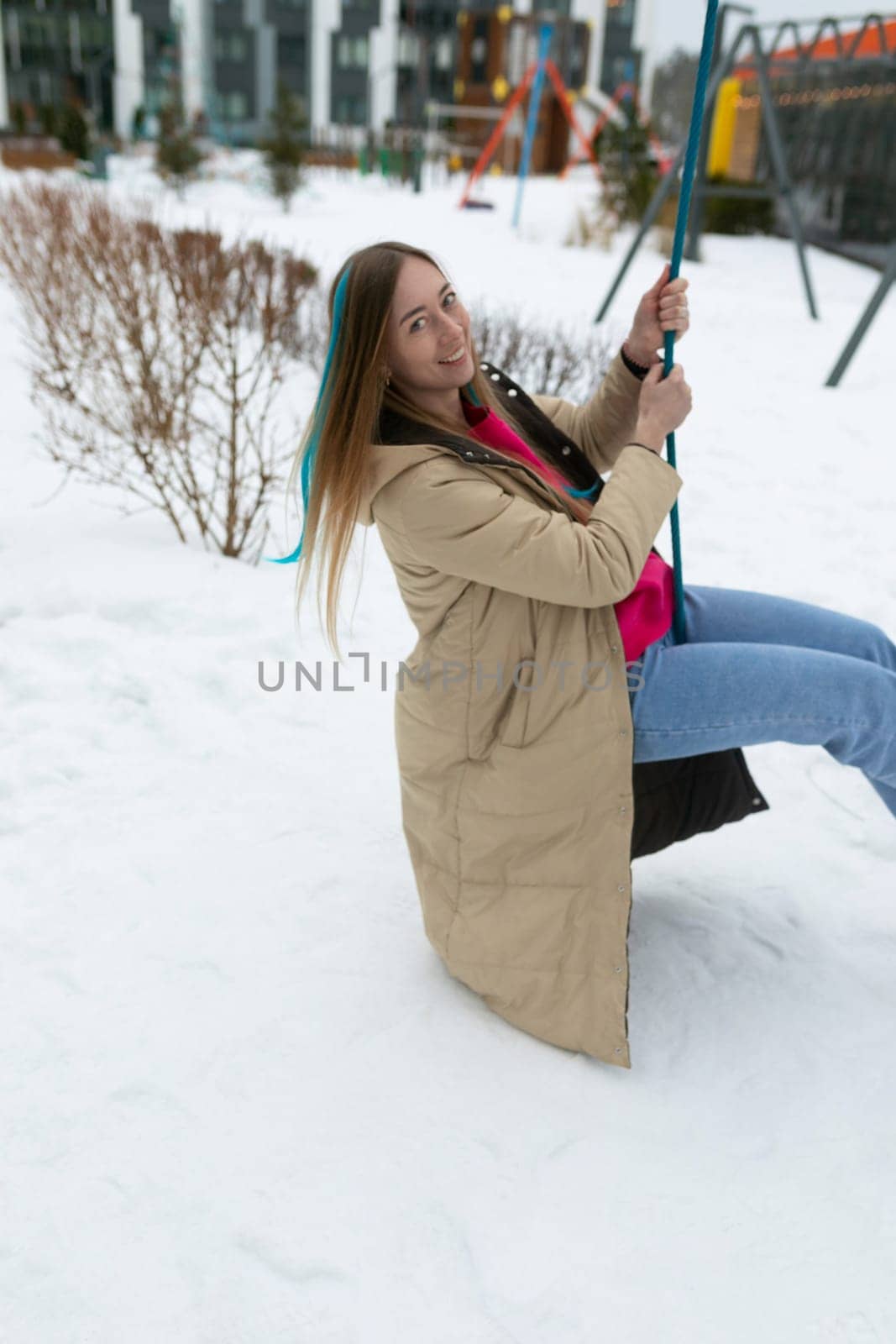 Woman Sitting on a Swing in the Snow by TRMK