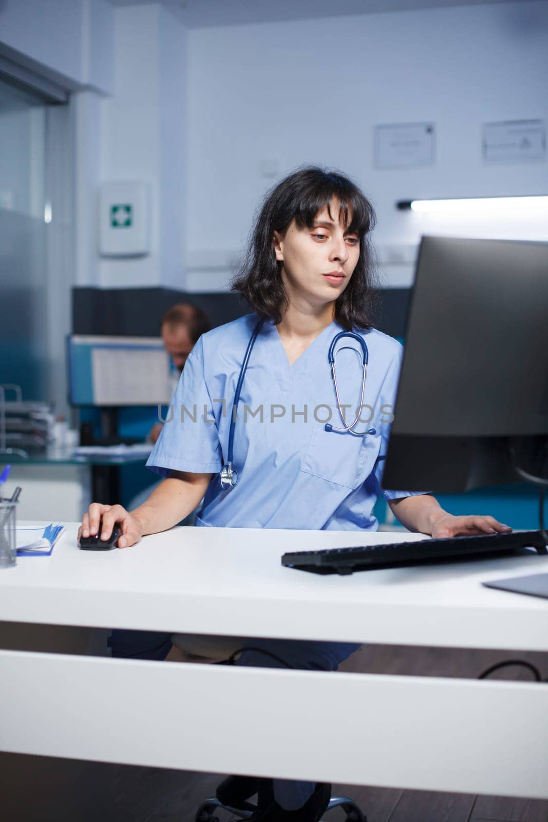 Female nurse using computer in office by DCStudio