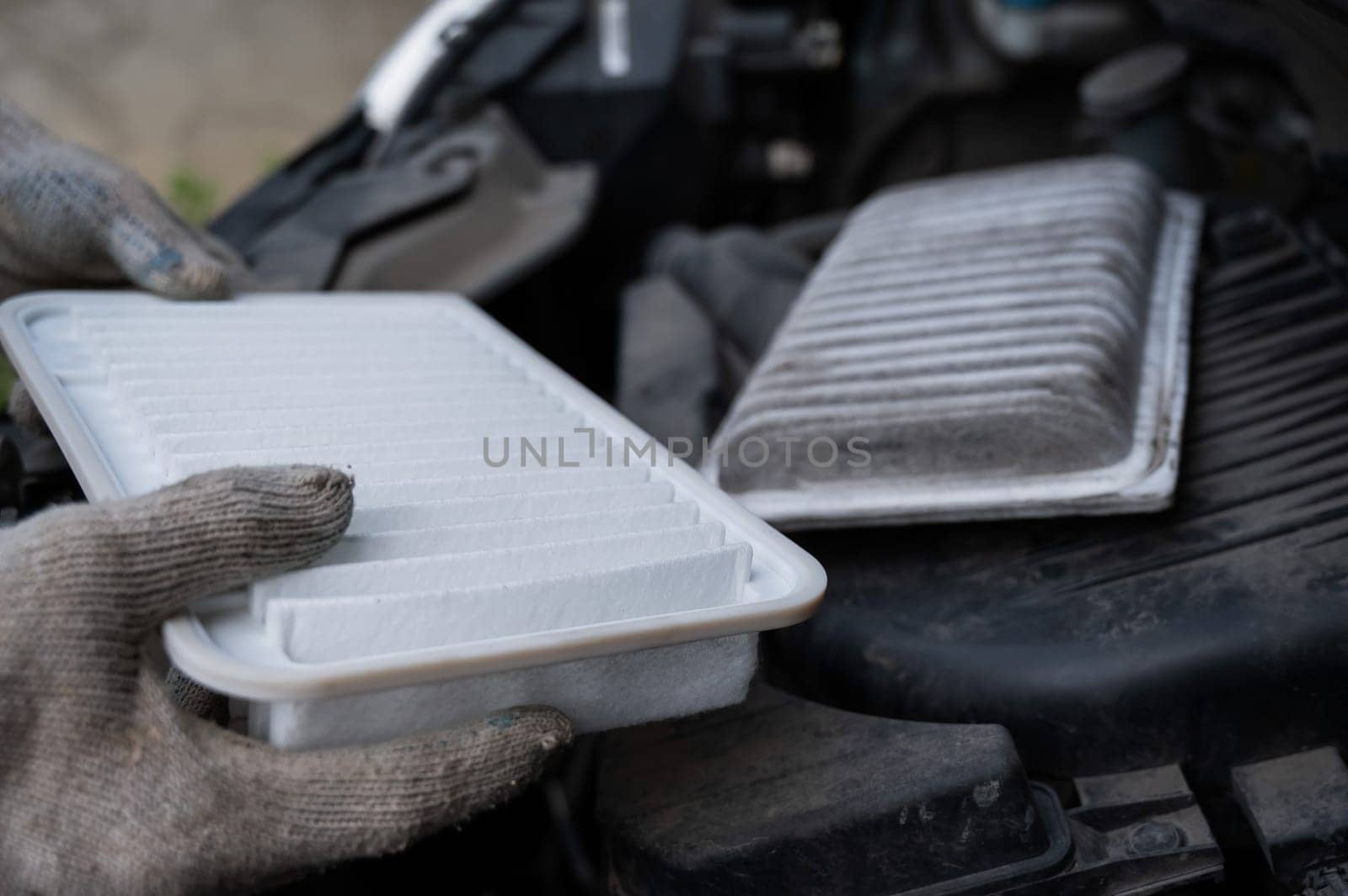 The master changes the air filter in the car engine