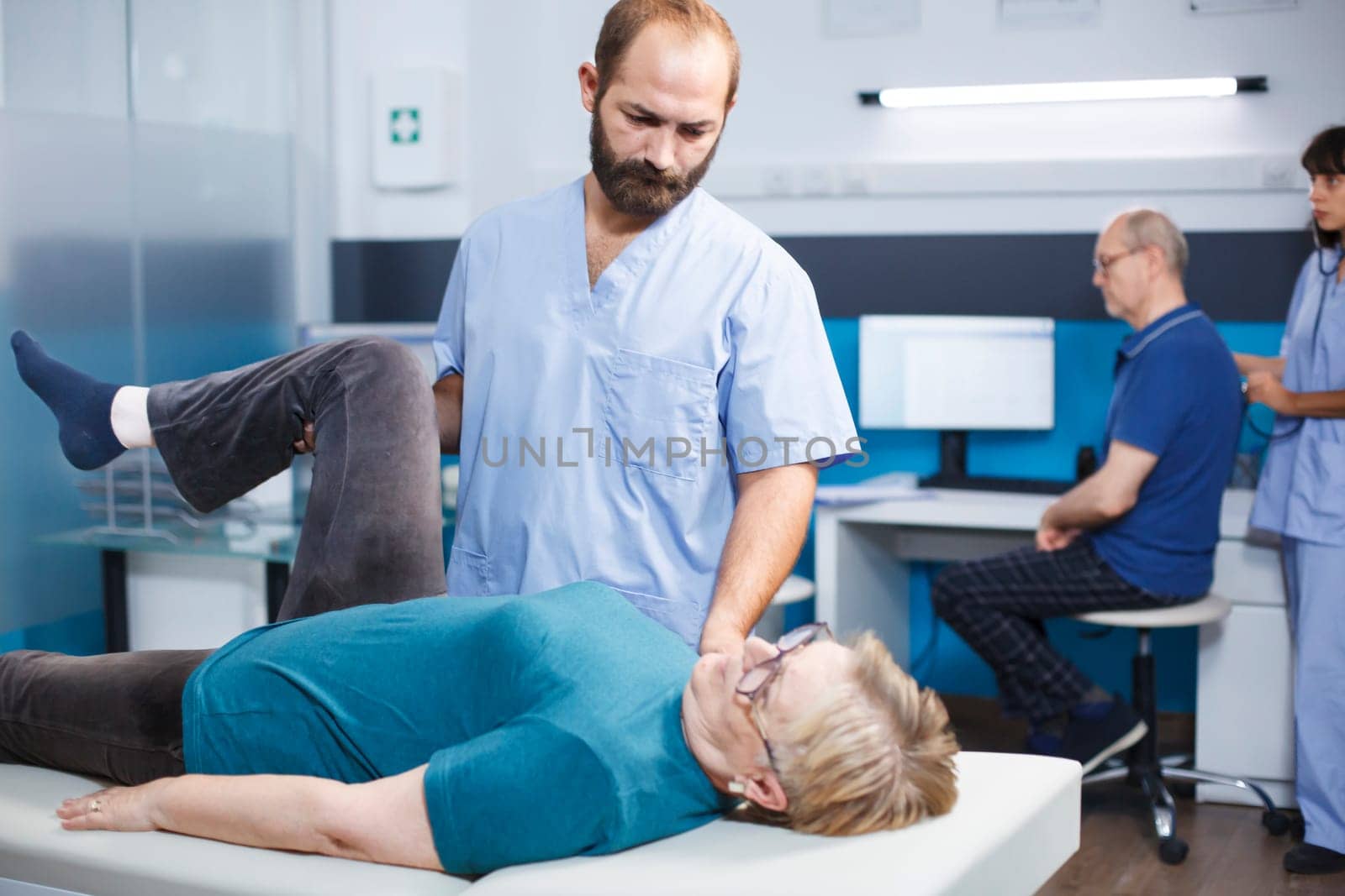 Doctor helping old woman with knee pain by DCStudio