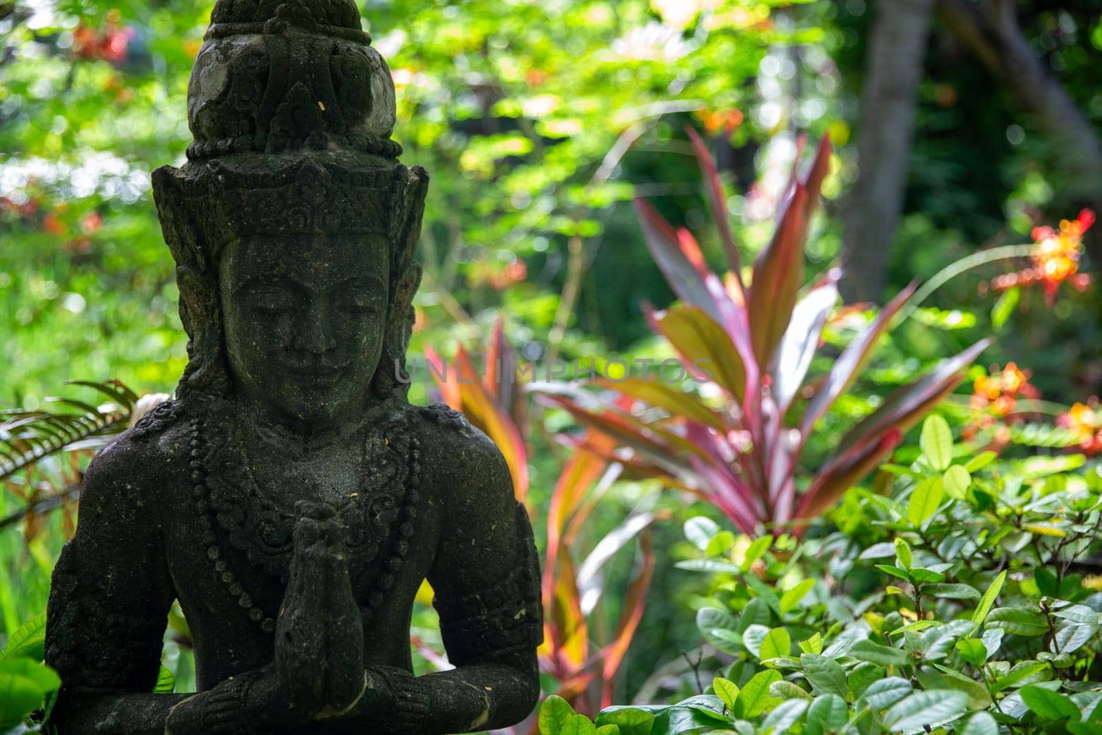 Balinese statue in a garden with lush plants