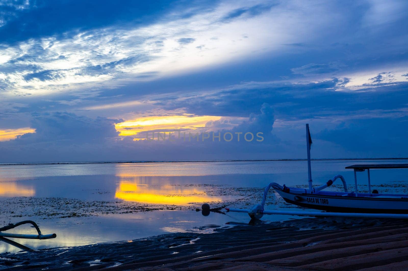 Indonesian Sunrise with a fishing boat on shore
