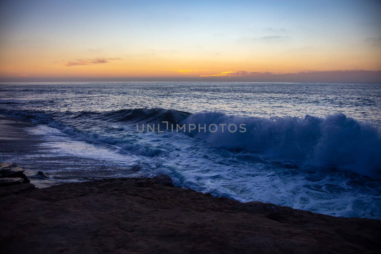 Weaves crashing into the shore during sunset