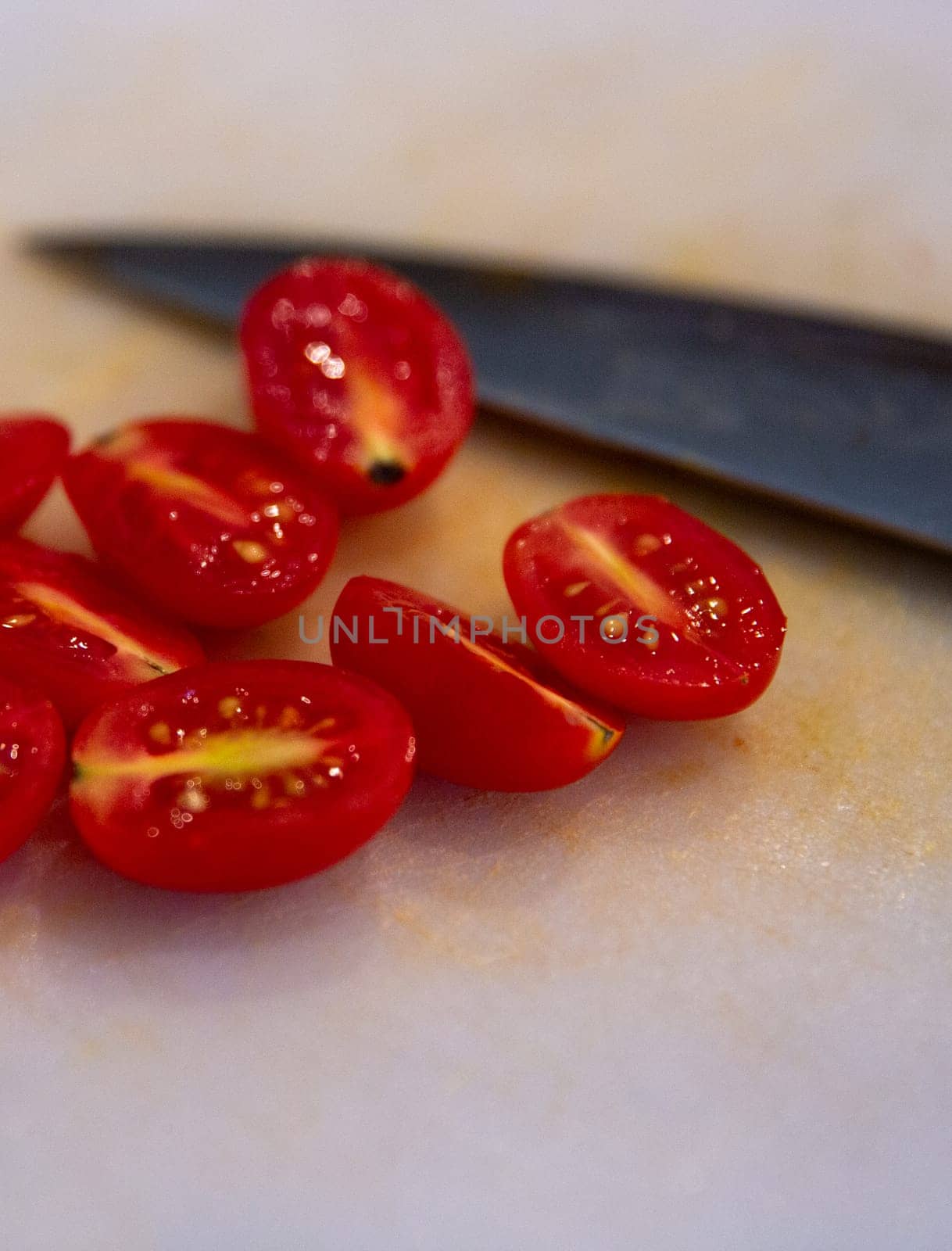 Knife next sliced tomatoes to be used as a topping