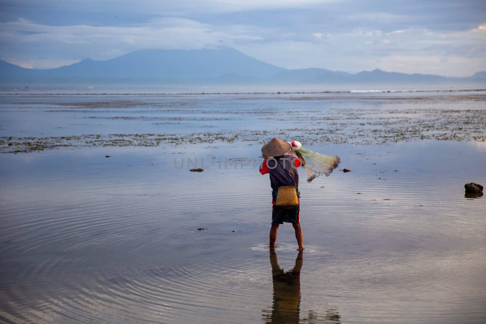 The lonely fisherman working on catching fish for his village