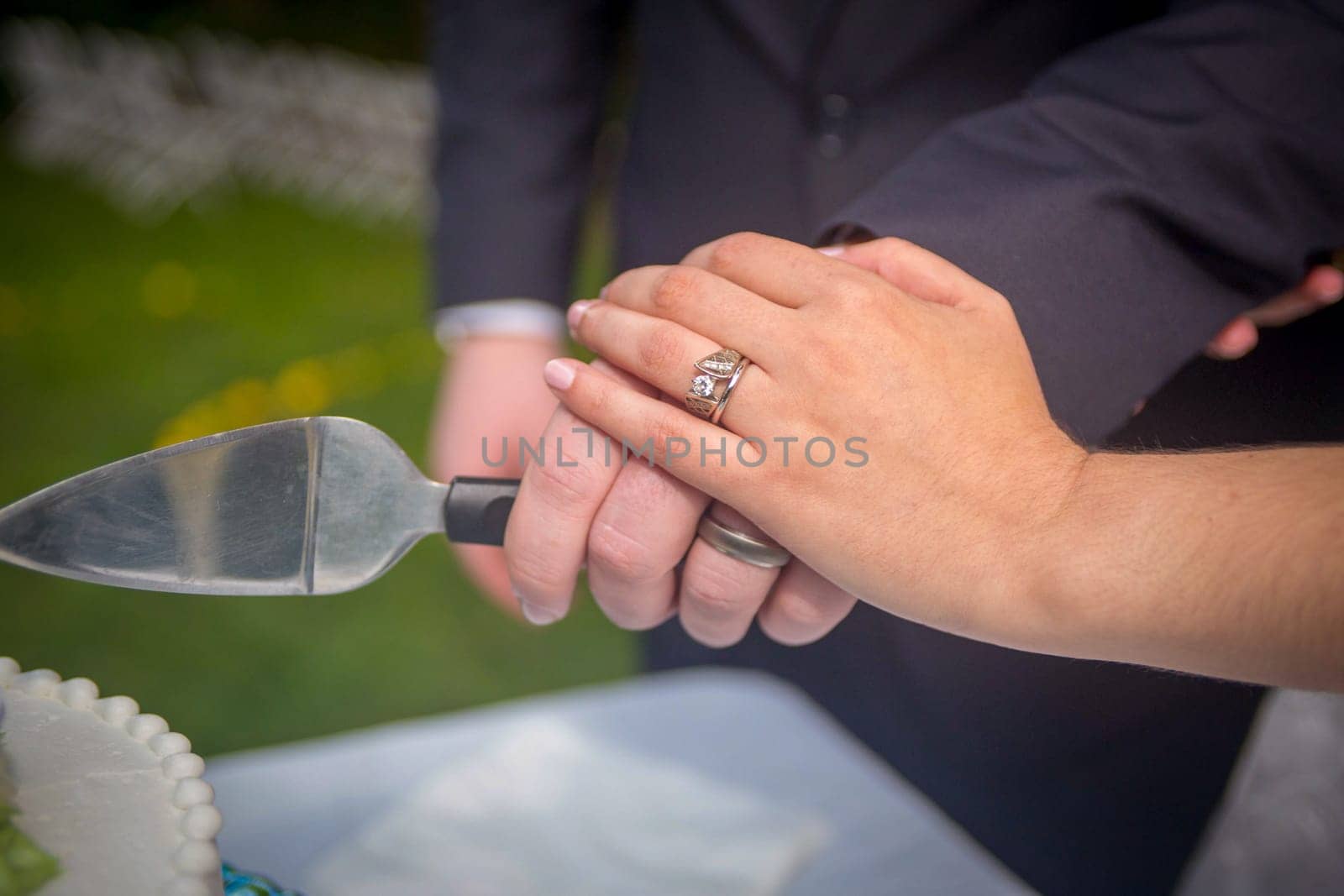 Bride and Grooms Hands cutting the wedding Cake