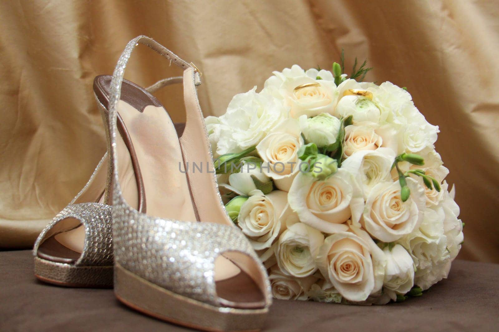 Rhinestone heels and bouquet holding the wedding bands