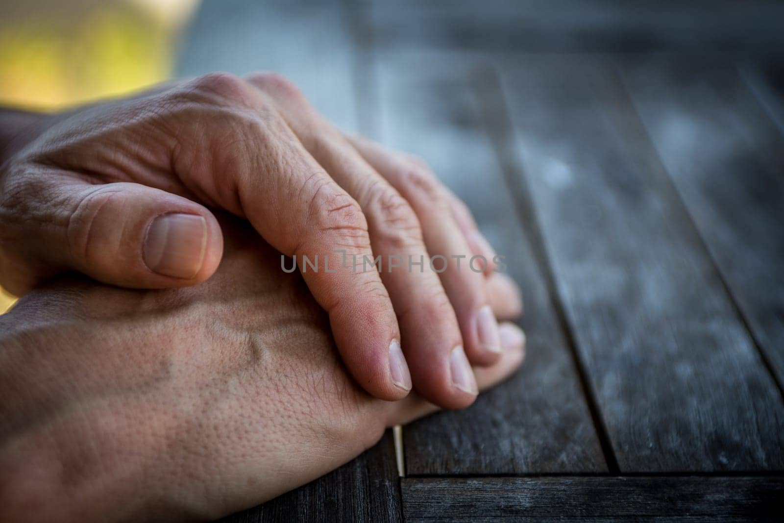 Mans hands on the table waiting patiently waiting for his food