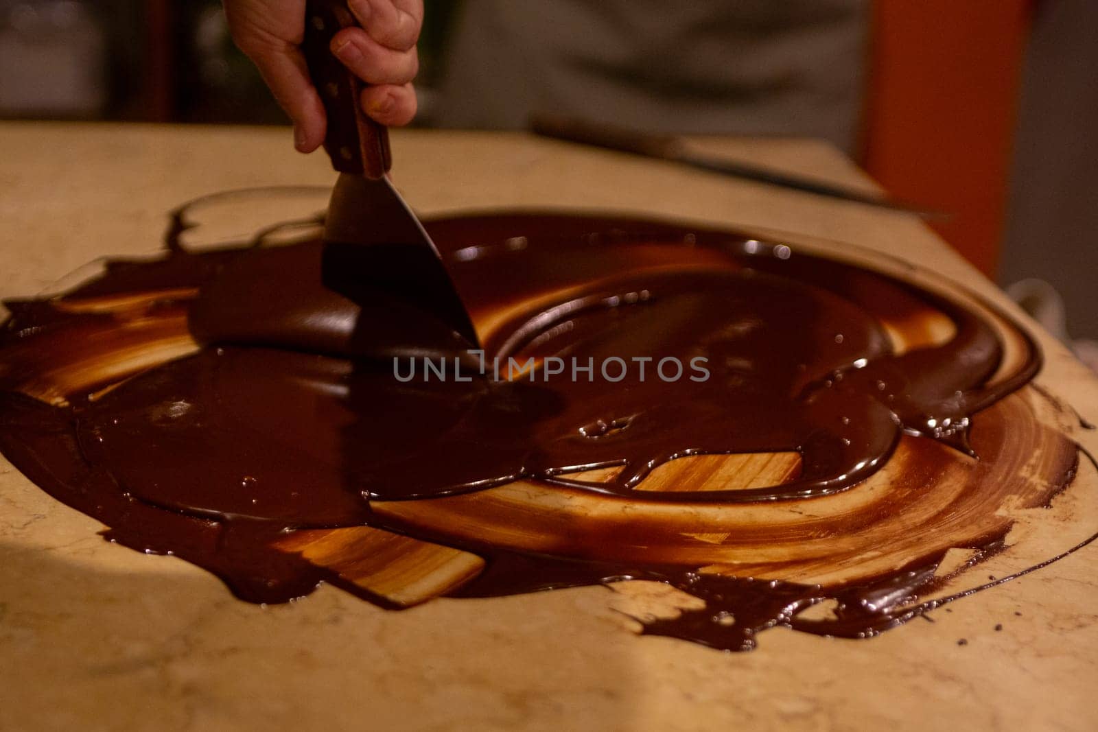 Chocolatier spreading chocolate as a demonstration