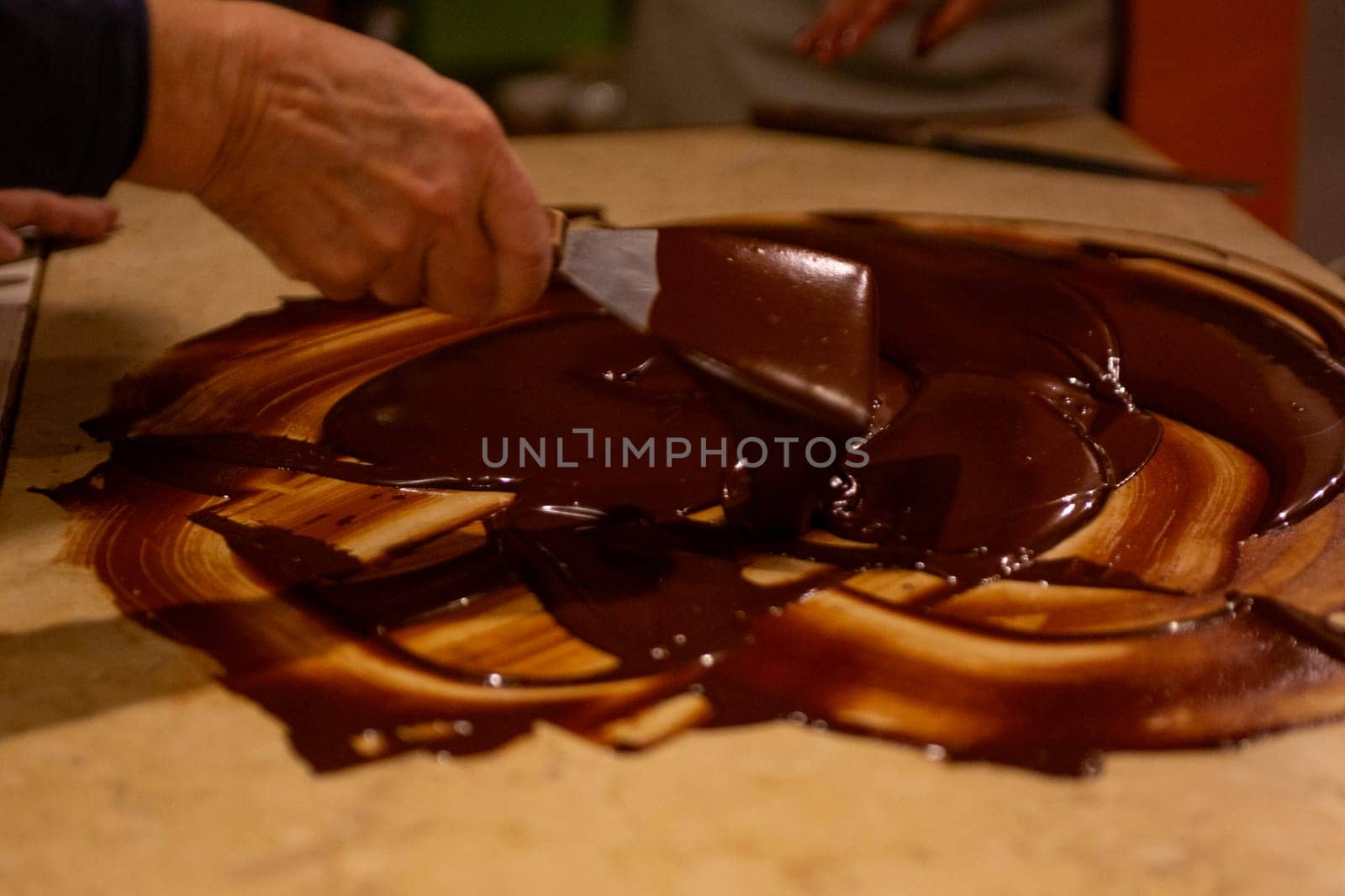 Chocolatier spreading chocolate as a demonstration