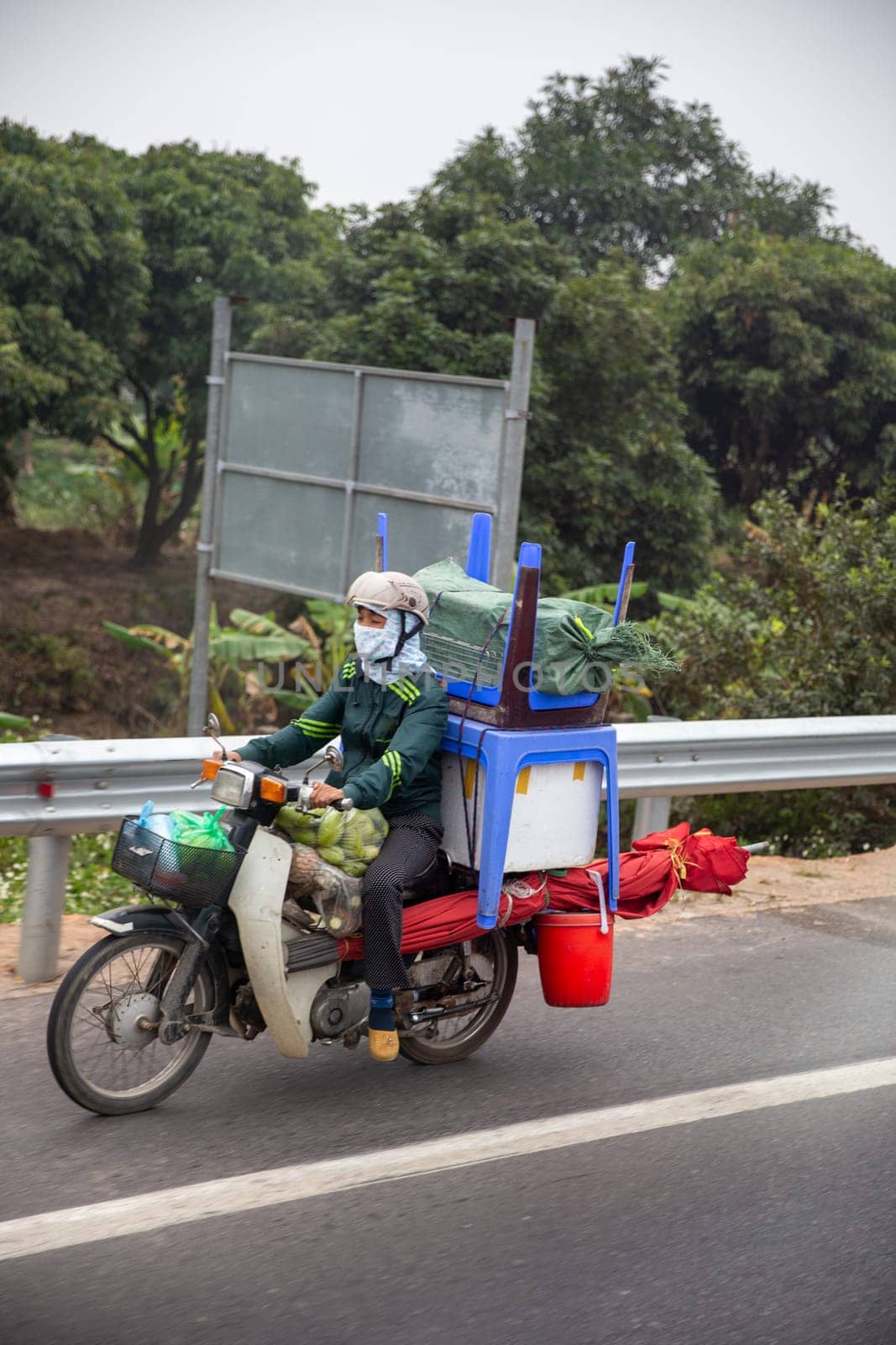 Asian transporting goods on a scooter