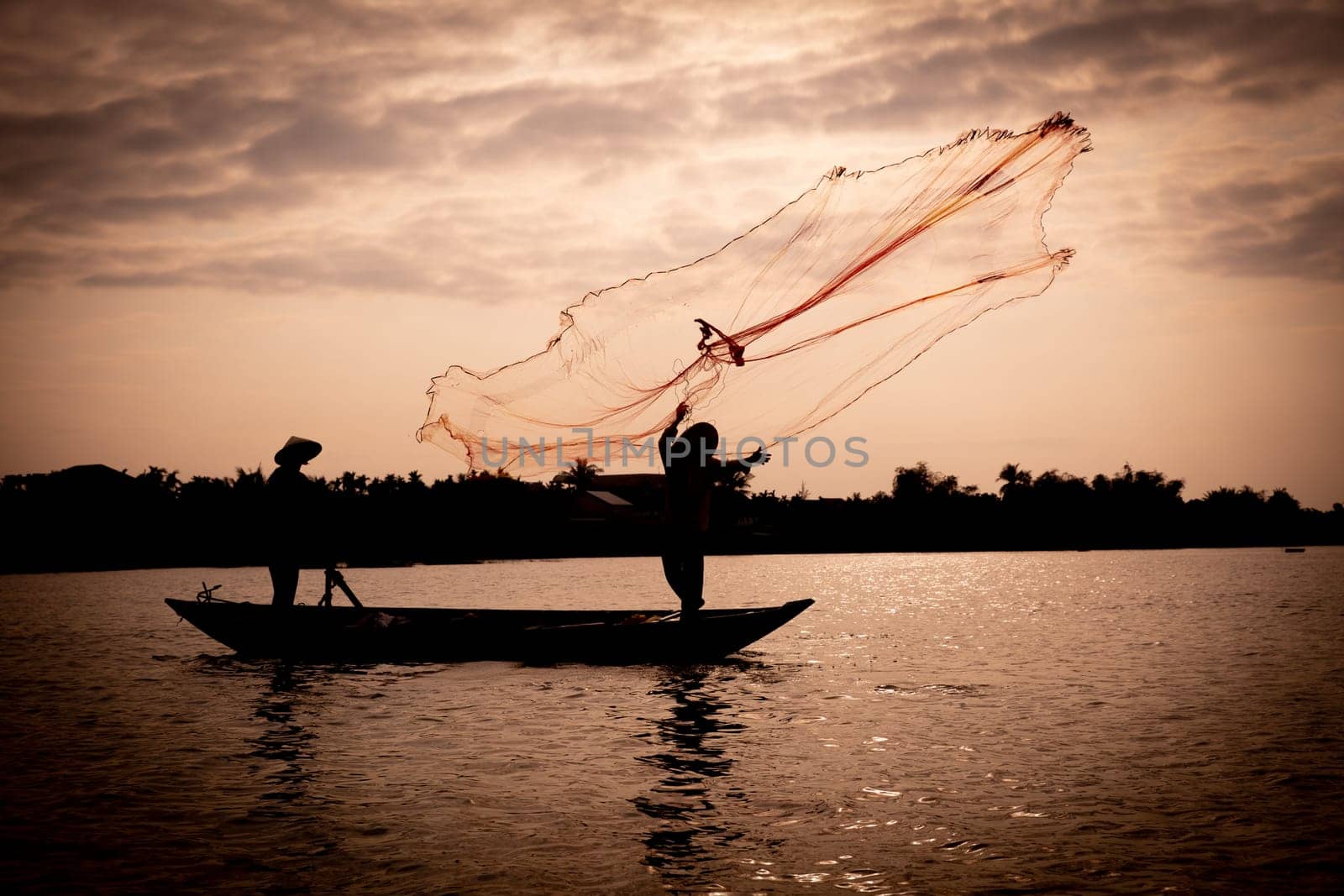 Vietnamese fisherman throwing a net to catch food for the village