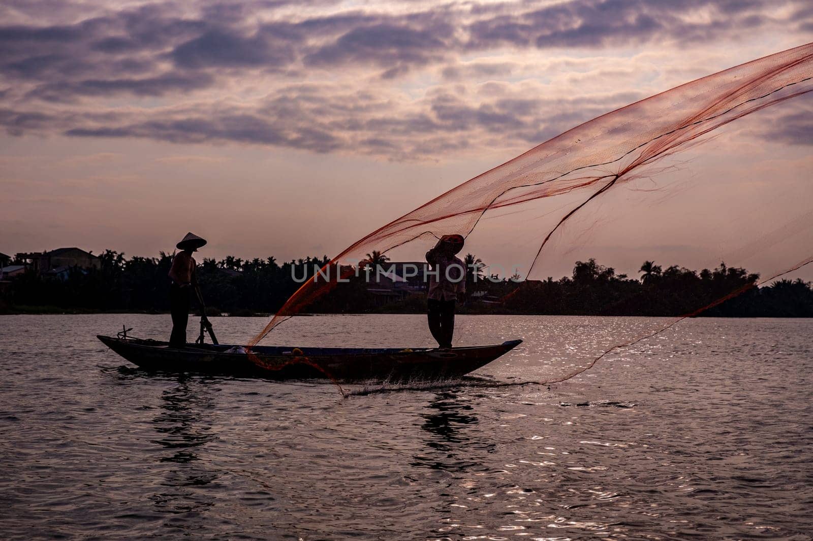Vietnamese fisherman throwing a net to catch food for the village
