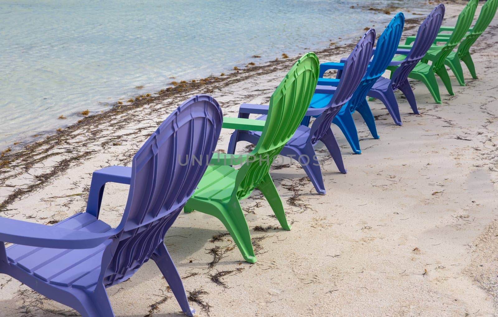 Colorful chairs on the beach for tourists to rest and have a drink.