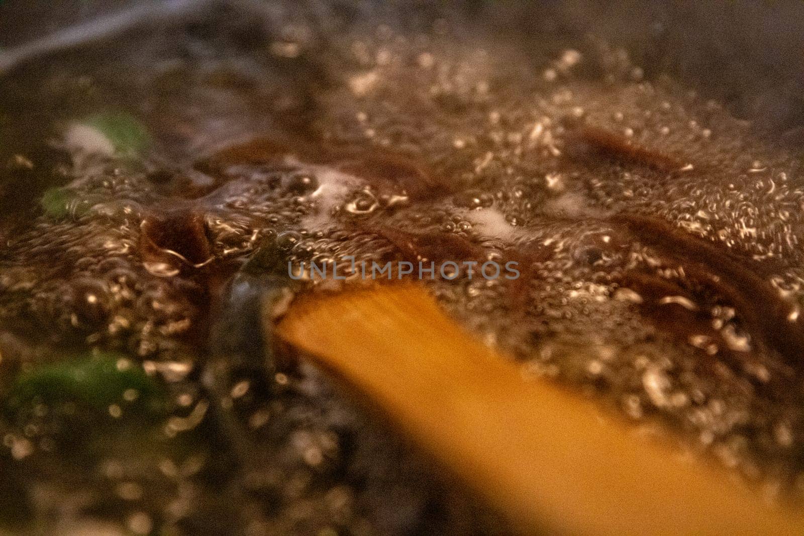 Pot of boiling pasta with a wooden spoon