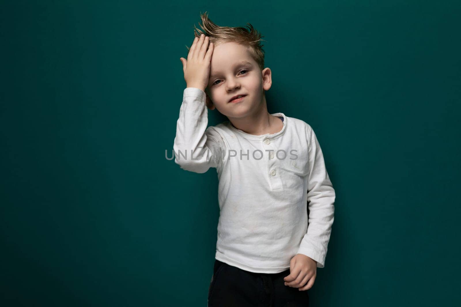 Little Boy Standing in Front of Green Wall by TRMK