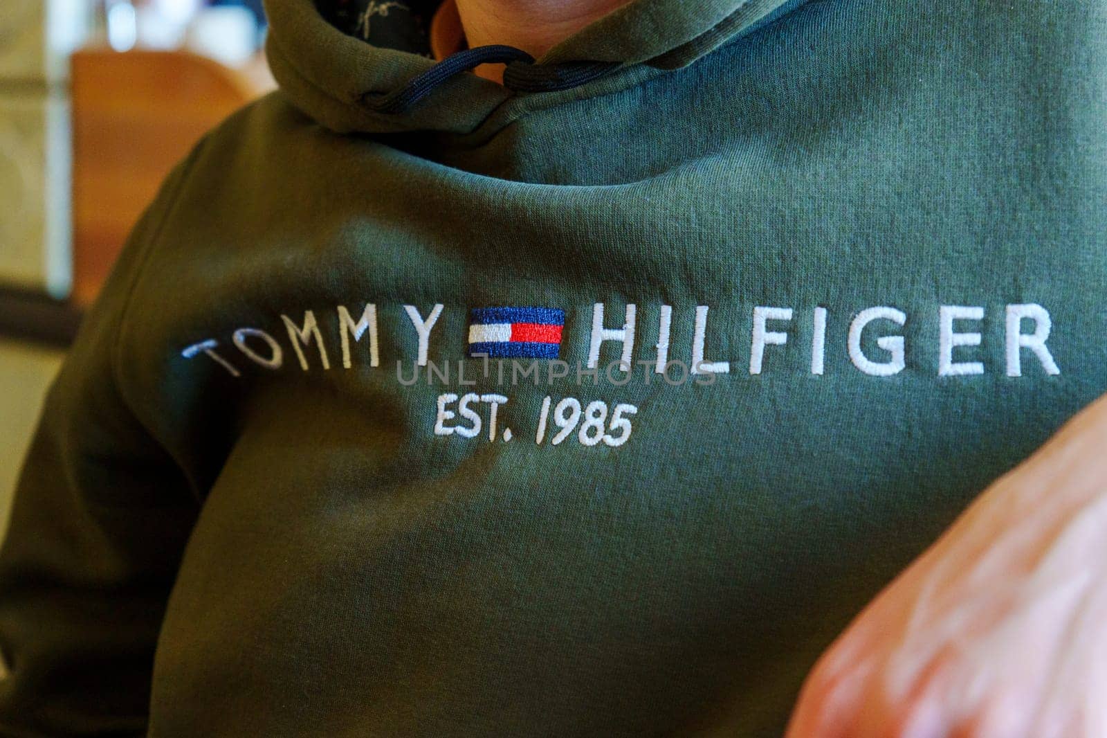 Tyumen, Russia-January 11, 2024: Person is wearing a green Tommy Hilfiger sweatshirt. Selective focus by darksoul72