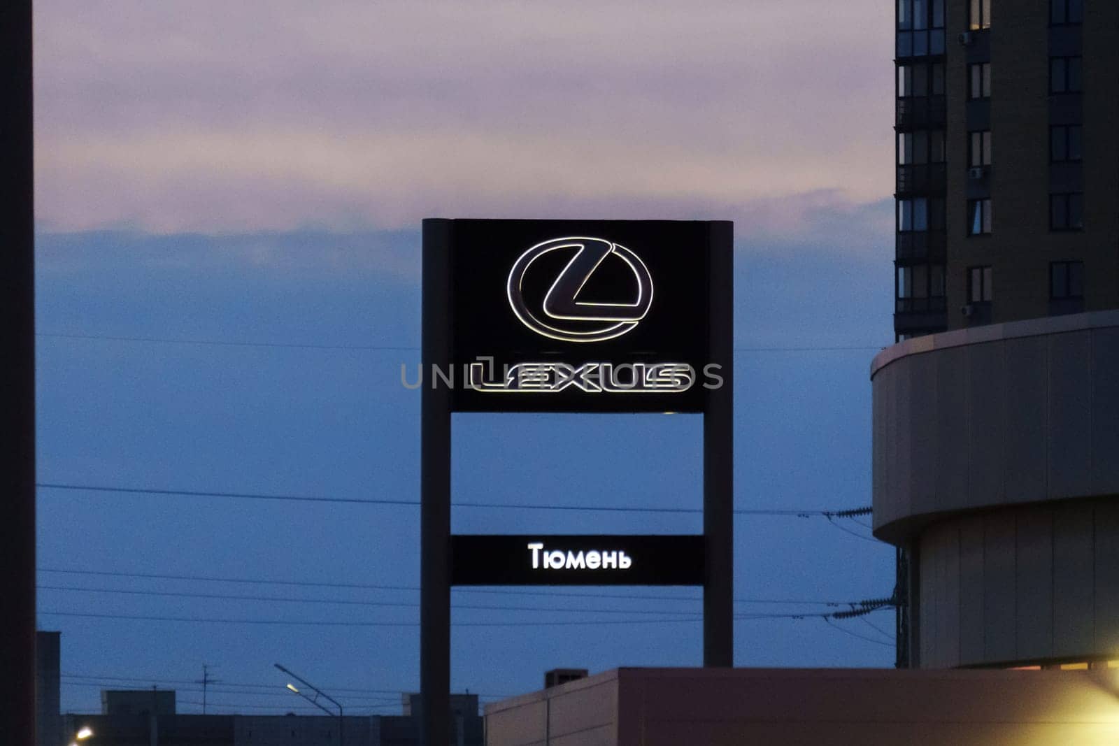 Tyumen, Russia-March 18, 2024: Sign displaying the Lexus logo for a car dealership stands prominently in front of a building.