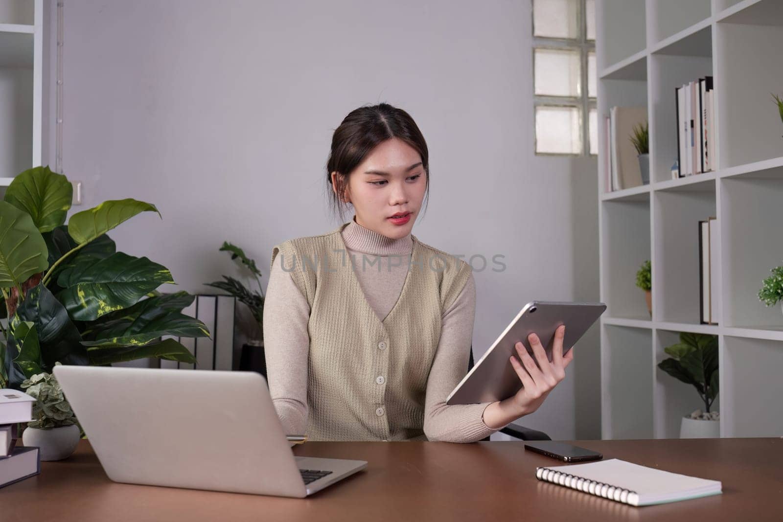 Asian female student studying online Video calls through Zoom about business administration and accounting subjects attentively.