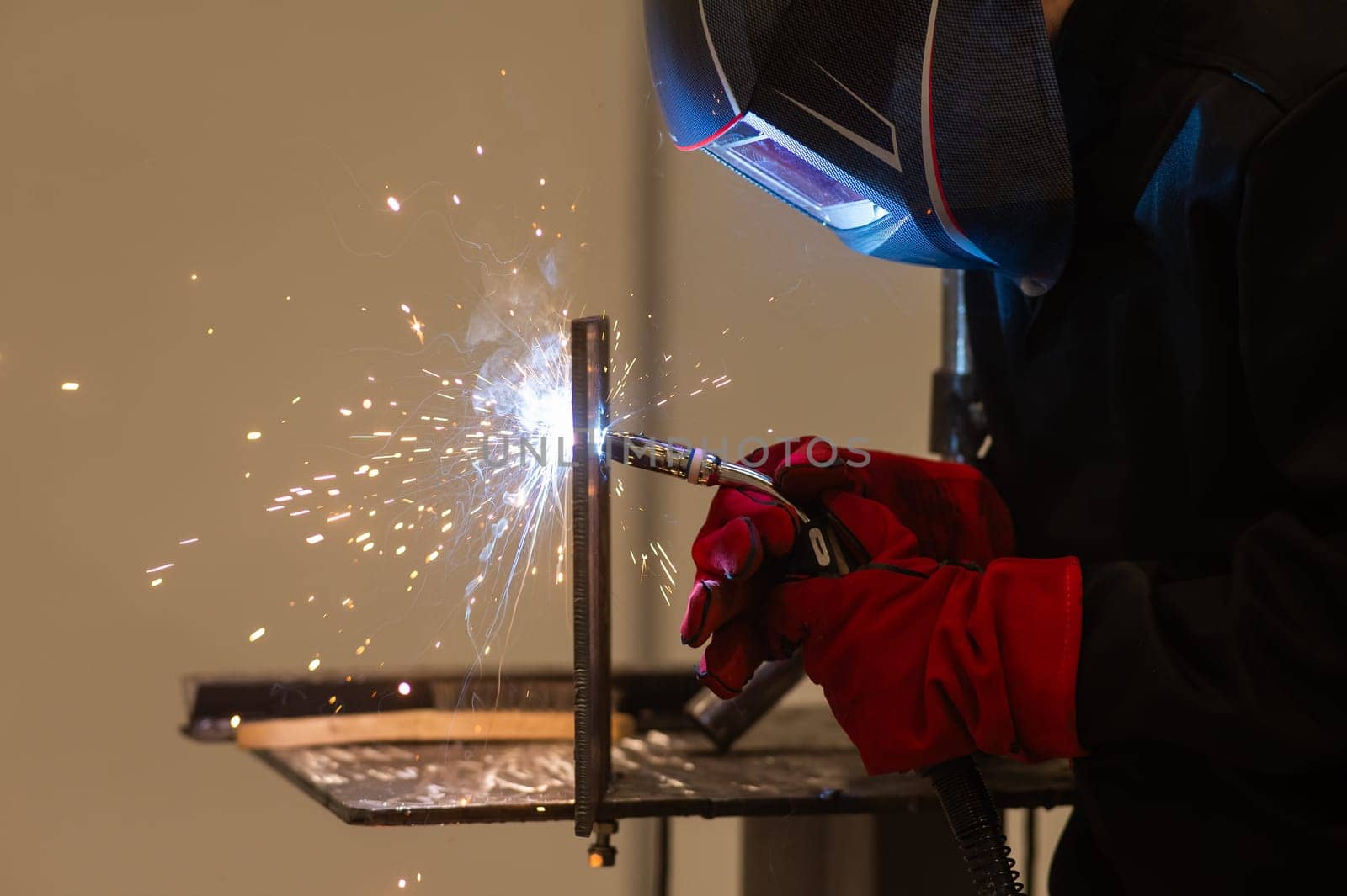 A man learns the craft of welding on a sample