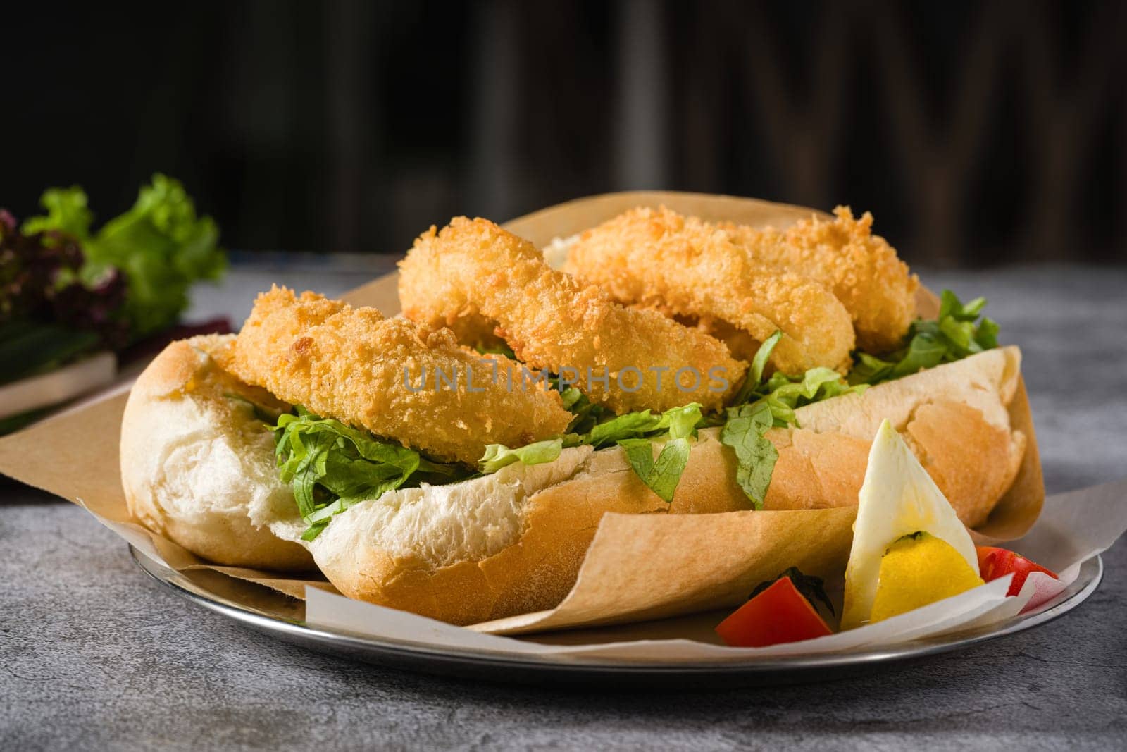 Deep fried squid in bread with greens on the side. Squid sandwich