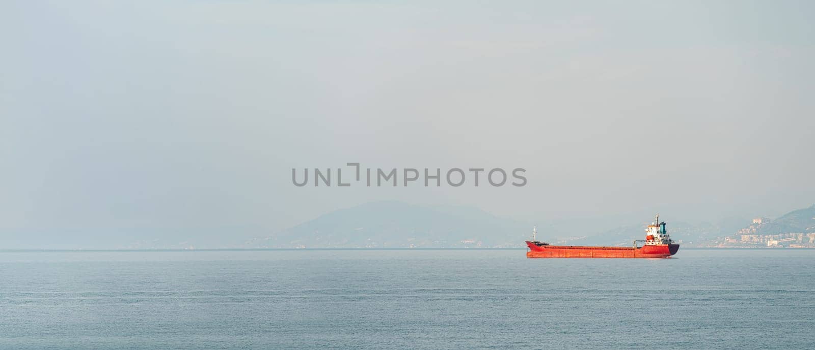 Orange general cargo ship anchored off the coast of Alanya, Antalya