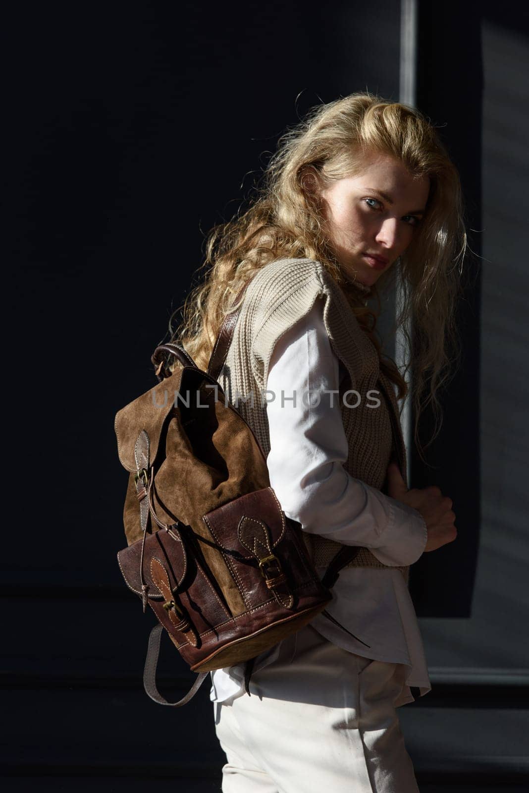 beautiful curly blond hair woman posing with a leather backpack by Ashtray25