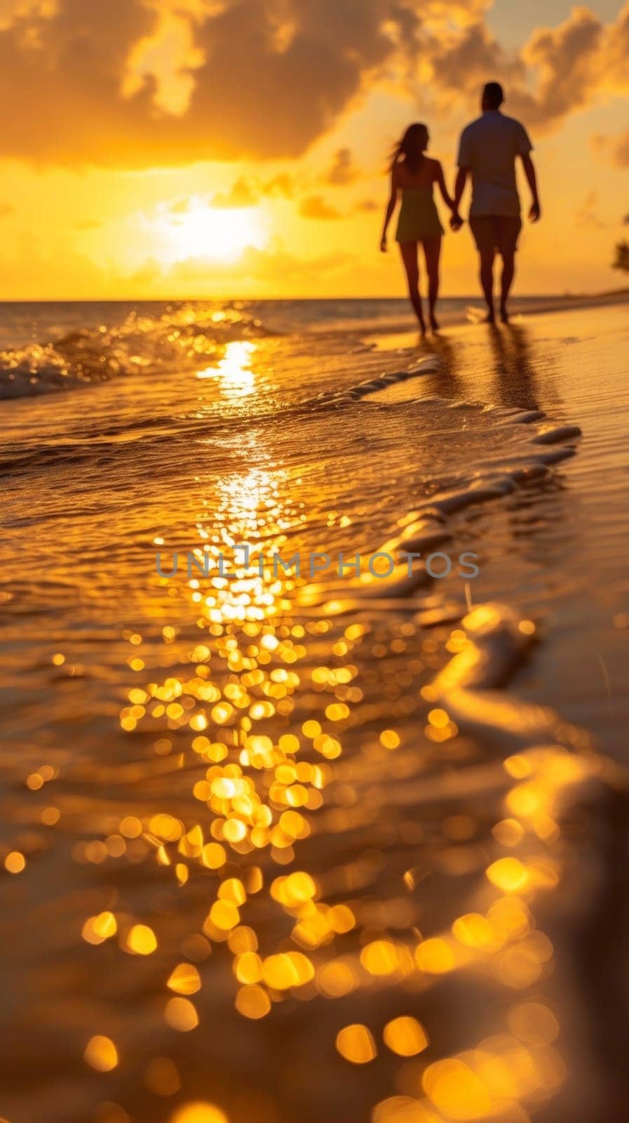 A couple walking on the beach at sunset holding hands
