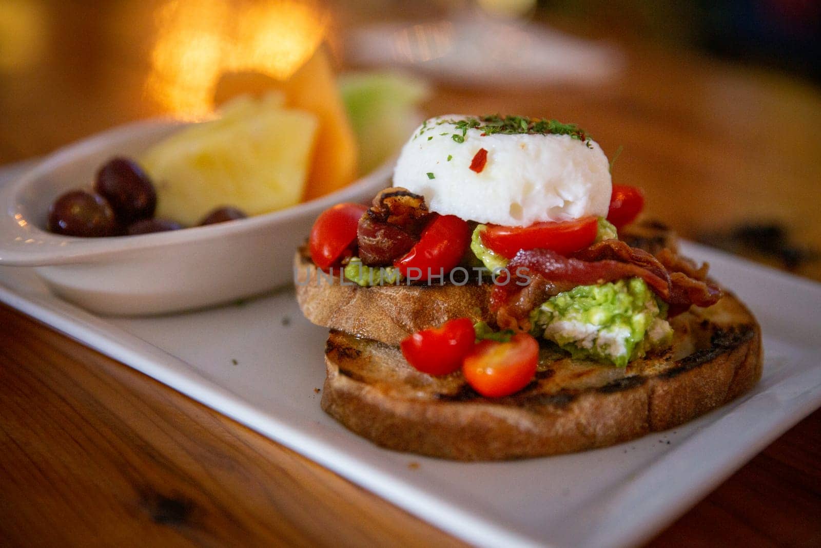 Avocado toast with eggs and fruit as a side