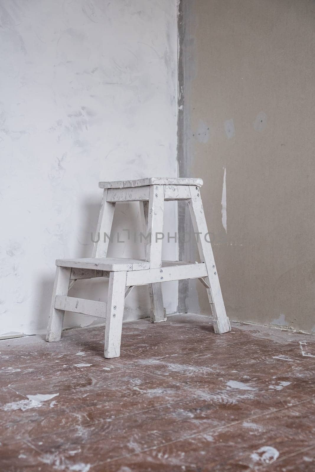 Applying decorative putty. A white repair chair. White abstract texture of surface covered with putty. textured background of filler paste applied with putty knife in irregular dashes and strokes.