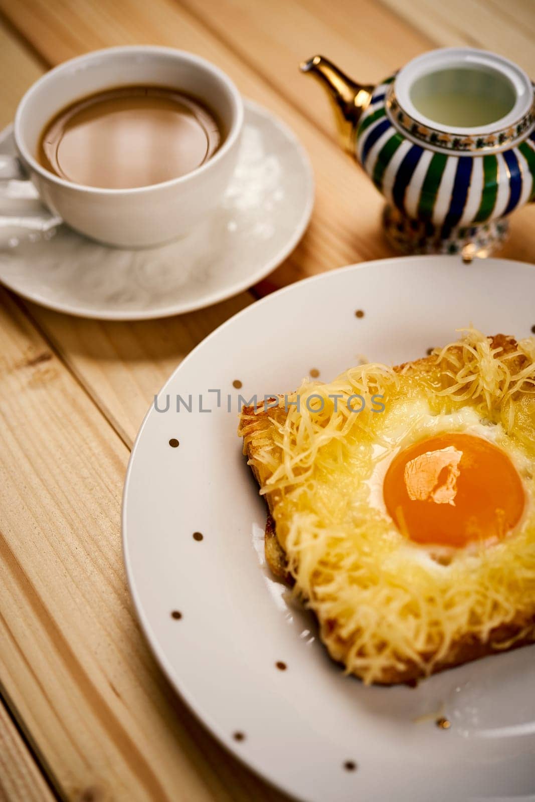 Delicious breakfast set with coffee and toast with fried egg on wooden kitchen table