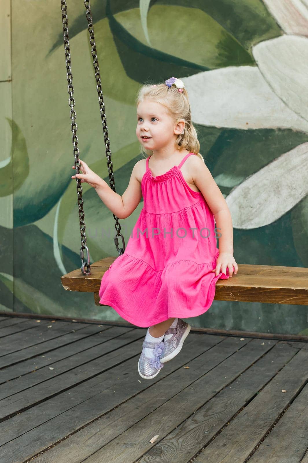 Child with hearing problem and cochlear implant dance in street, deaf kid began to hear. Hearing loss in childhood and treatment concept. Copy space and empty place for text.