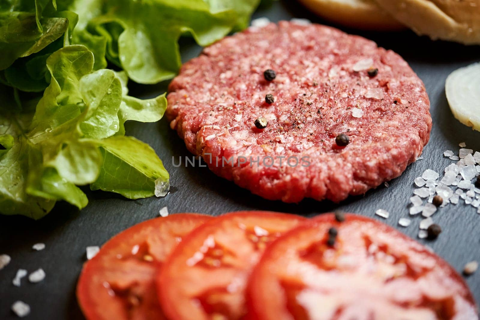 fresh beef for burger on the table with lettuce, onion and bread