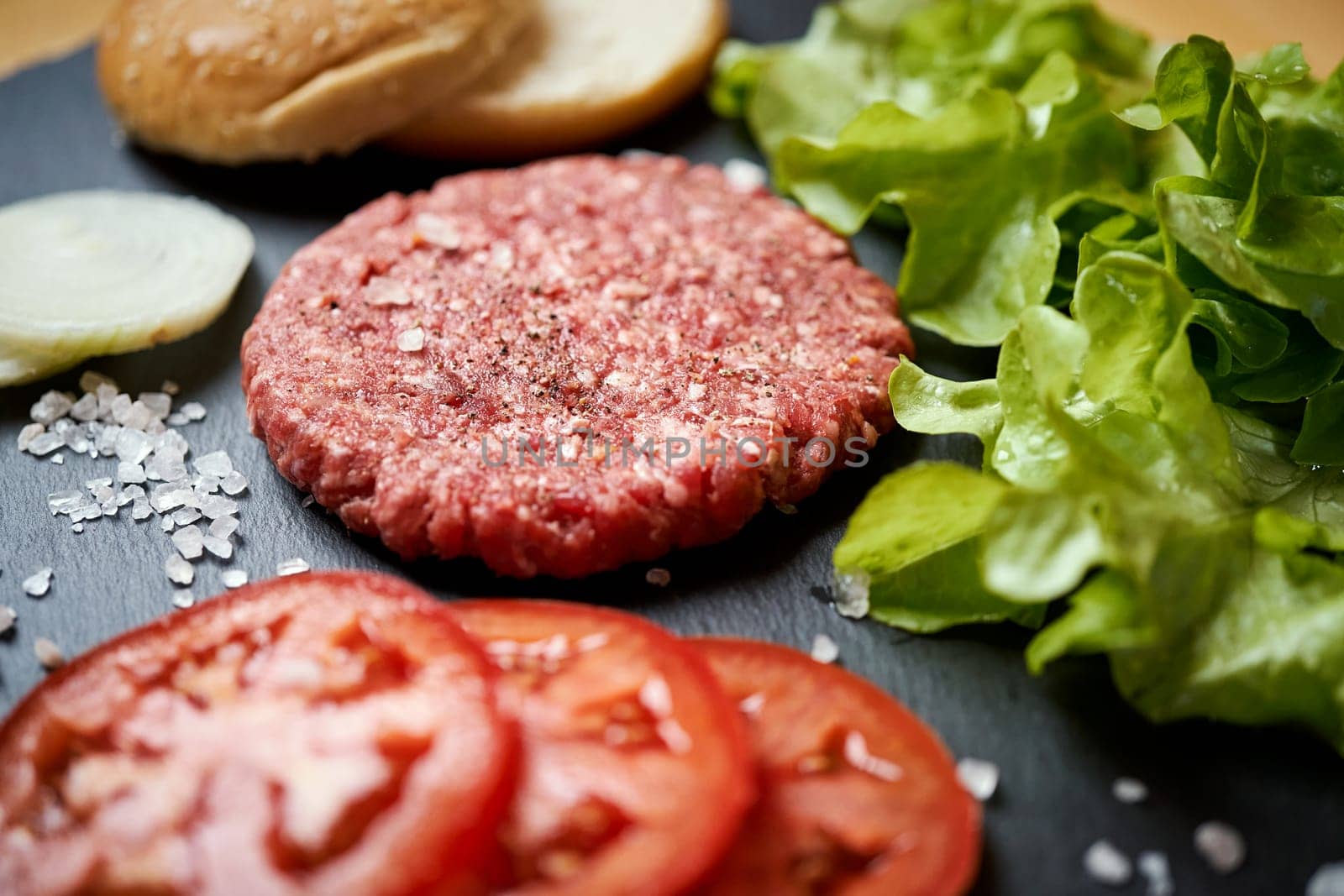 fresh beef for burger on the table with lettuce, onion and bread