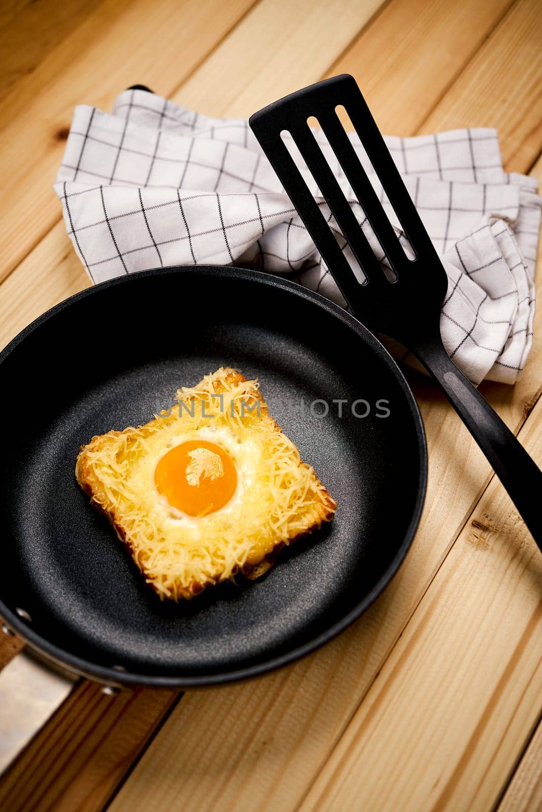 Delicious toast with fried egg and cheese in pan on wooden kitchen table