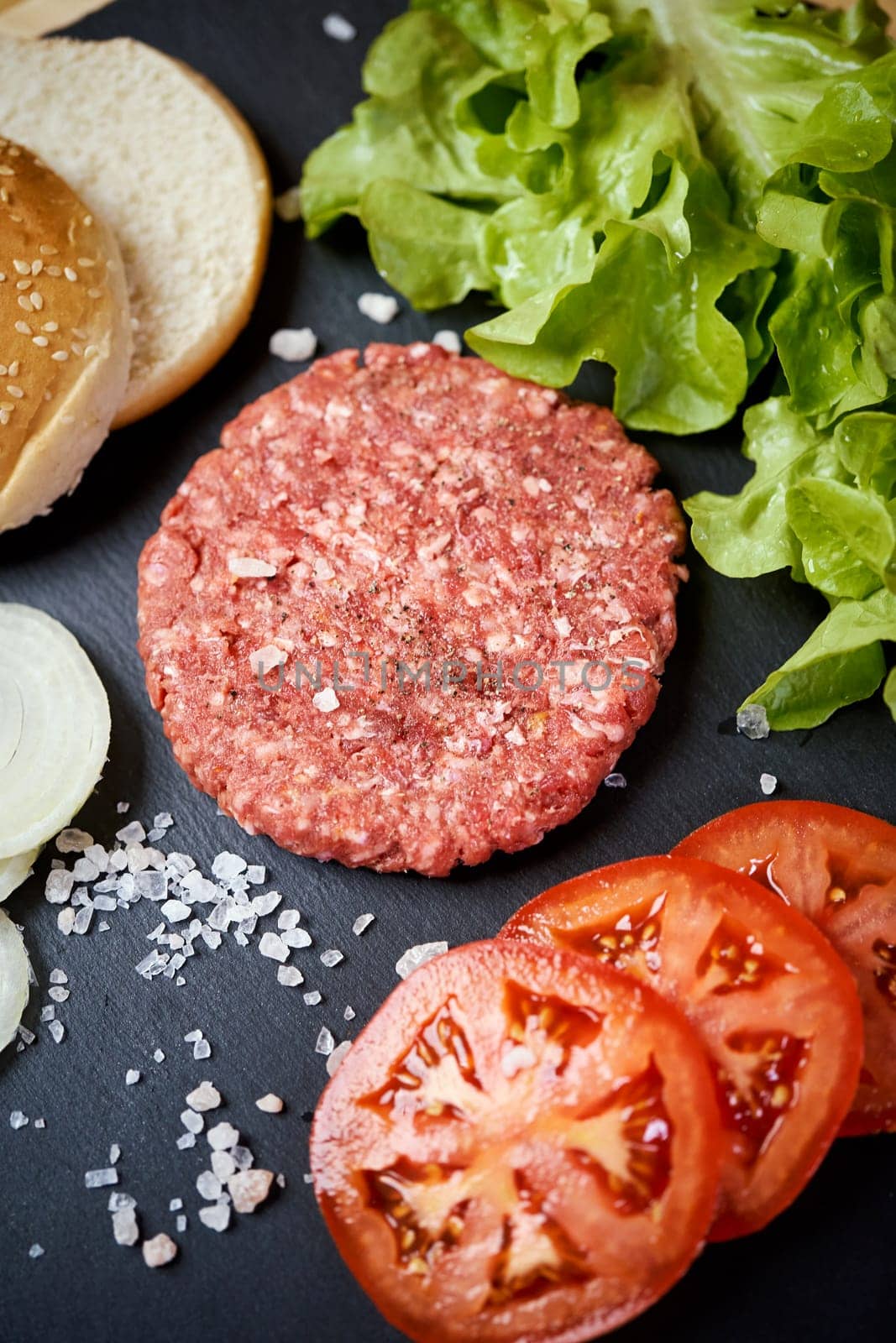 fresh beef for burger on the table with lettuce, onion and bread