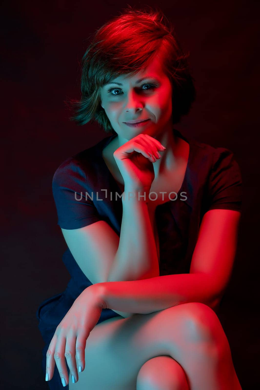 Beautiful attractive young woman posing in neon light in studio by superstellar