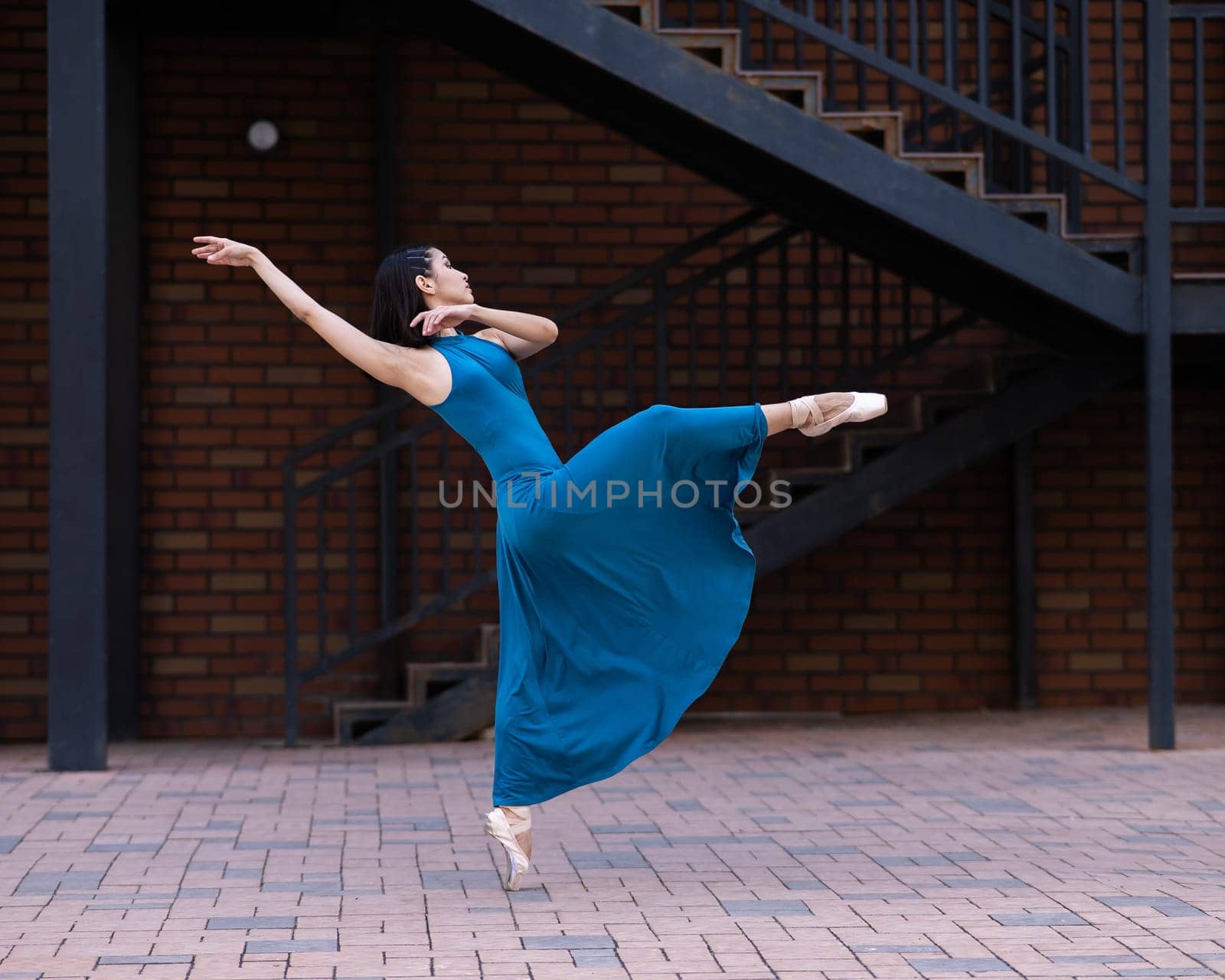 Beautiful Asian ballerina dancing outdoors. Urban landscape. by mrwed54