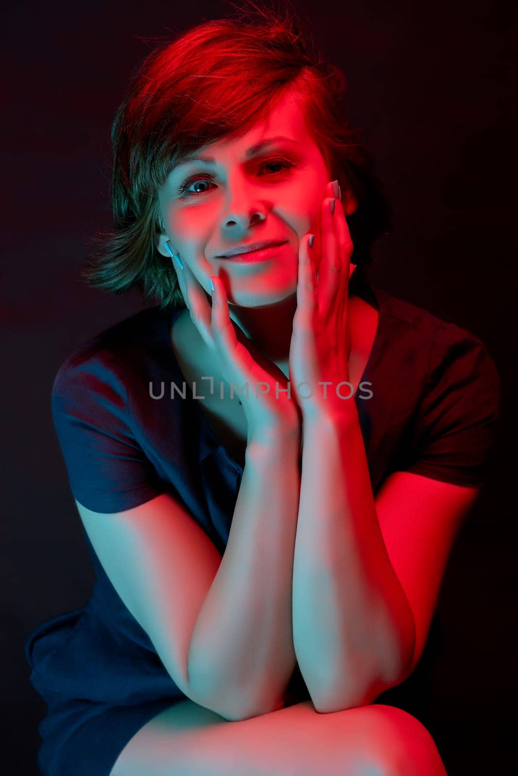 Beautiful attractive young woman posing in neon light in studio by superstellar