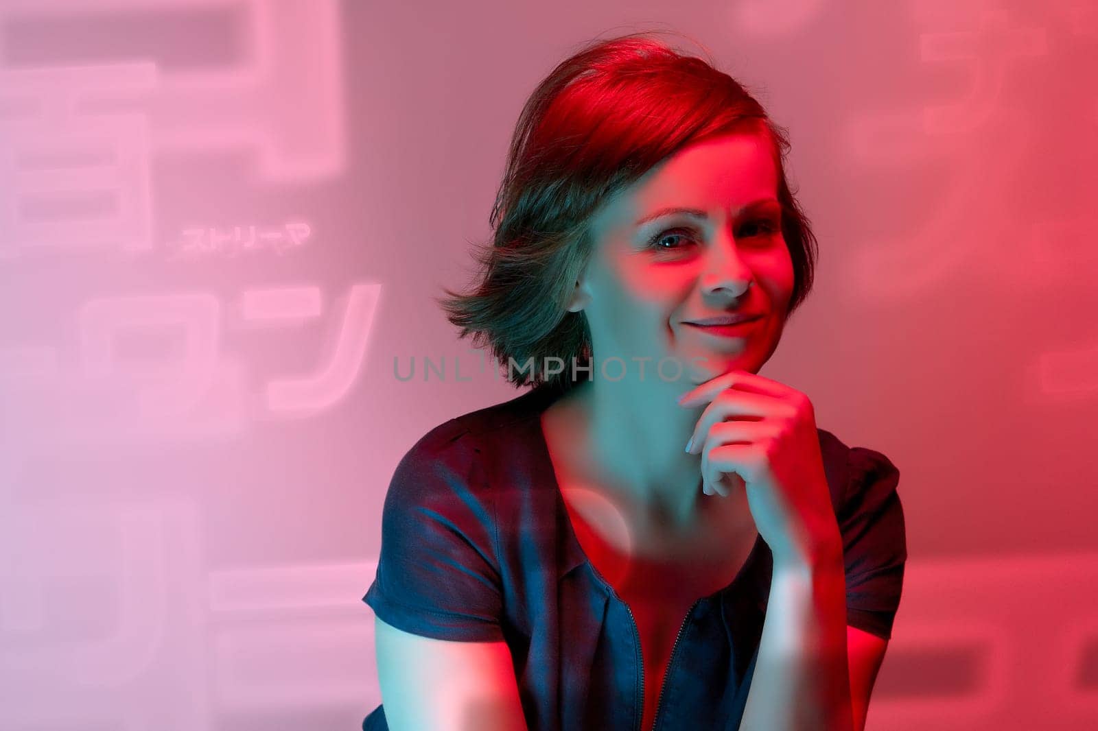 Beautiful attractive young woman posing in neon light in studio by superstellar