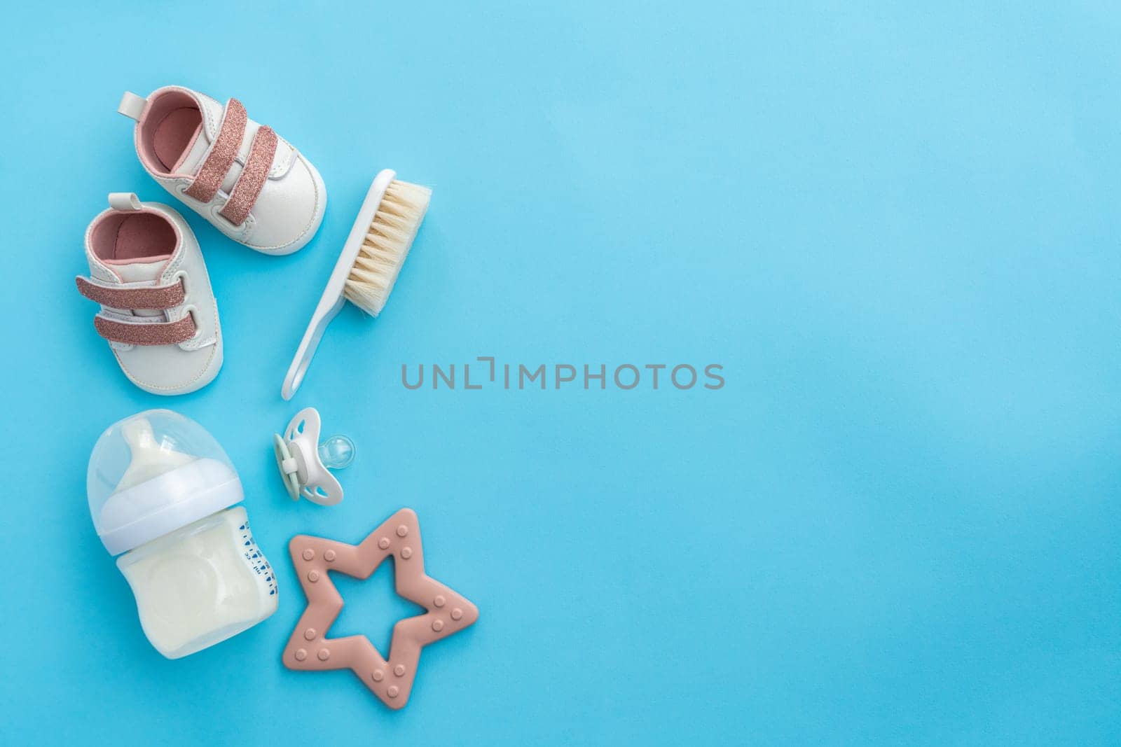 From above, an assortment of newborn accessories is neatly presented on a refreshing blue