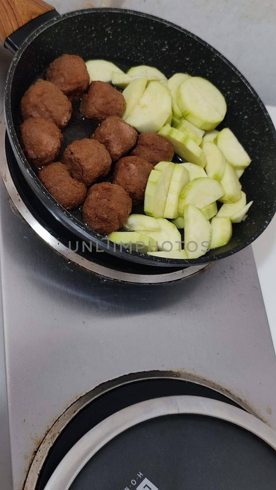 zucchini and cutlets meatballs in a frying pan, homemade food, cooking. High quality photo